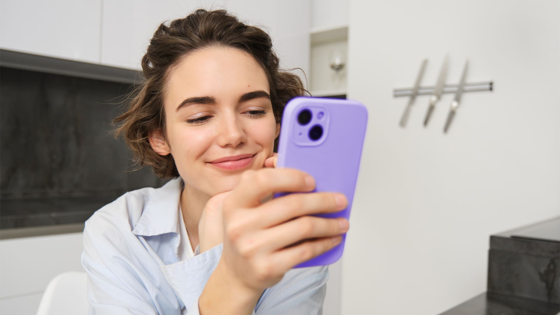 Mujer joven con smartphone en su mano chateando con chatbot