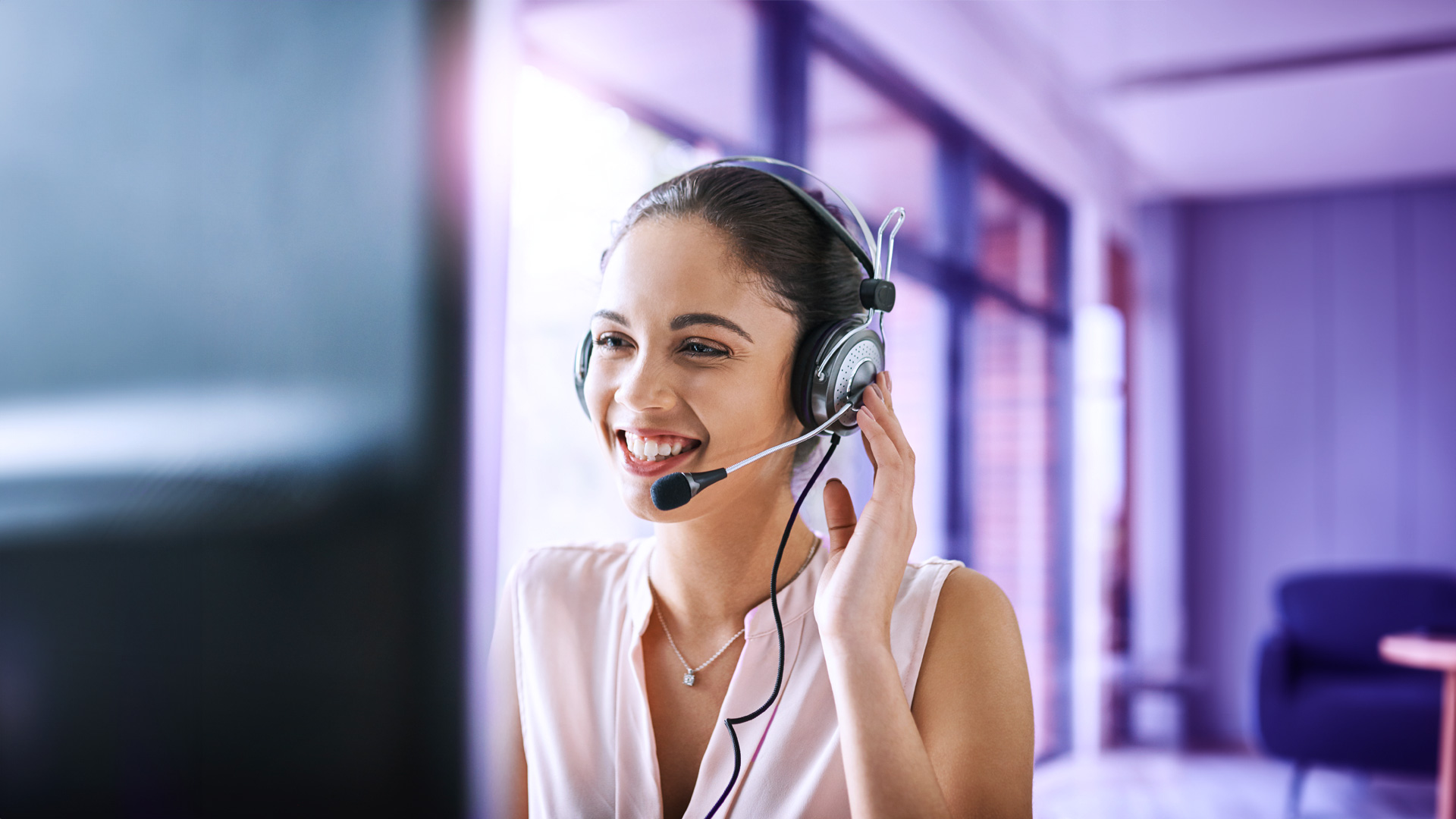 Mujer trabajadora de call center de llamadas salientes sonriendo mientras habla con clientes potenciales por el automarcador