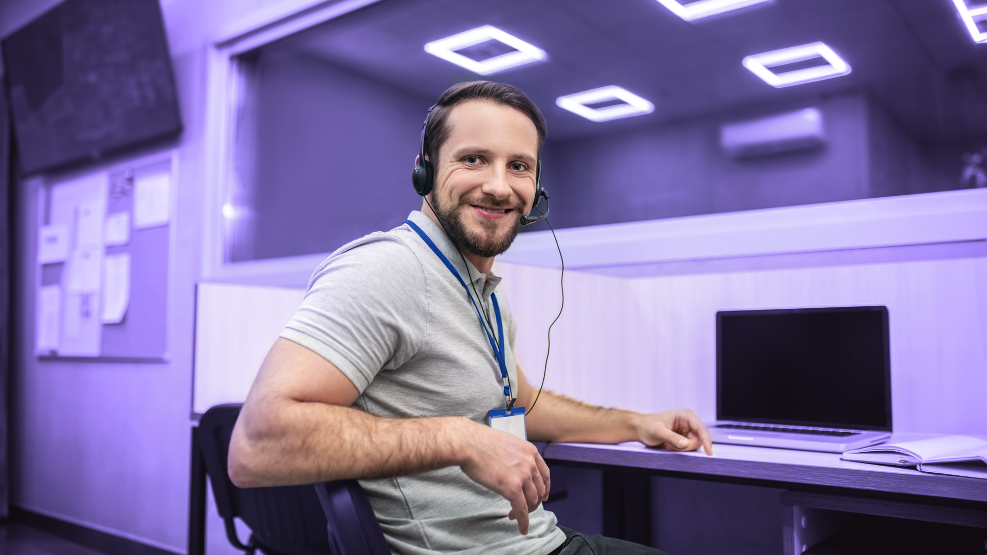 Hombre sonriendo a cámara trabajando en un contact center