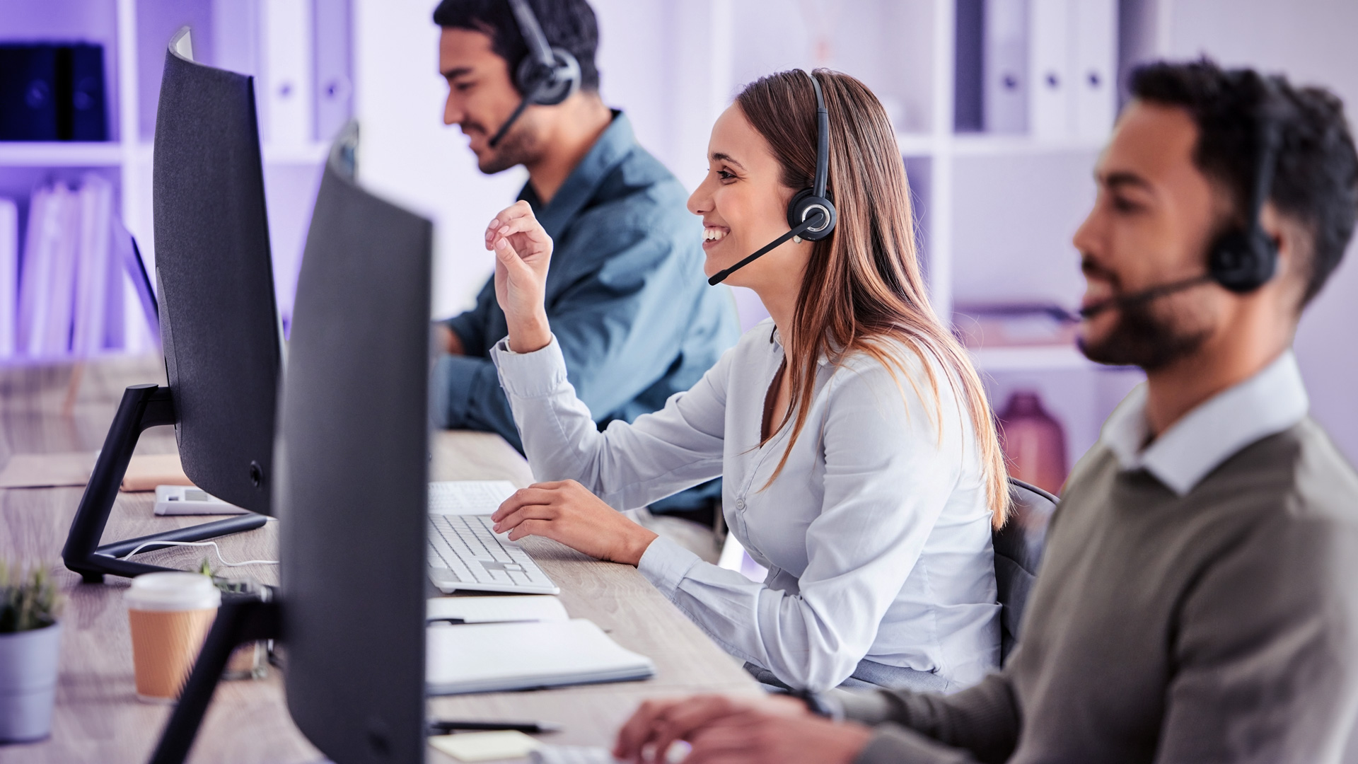 Tres agentes de contact center trabajando sonriendo