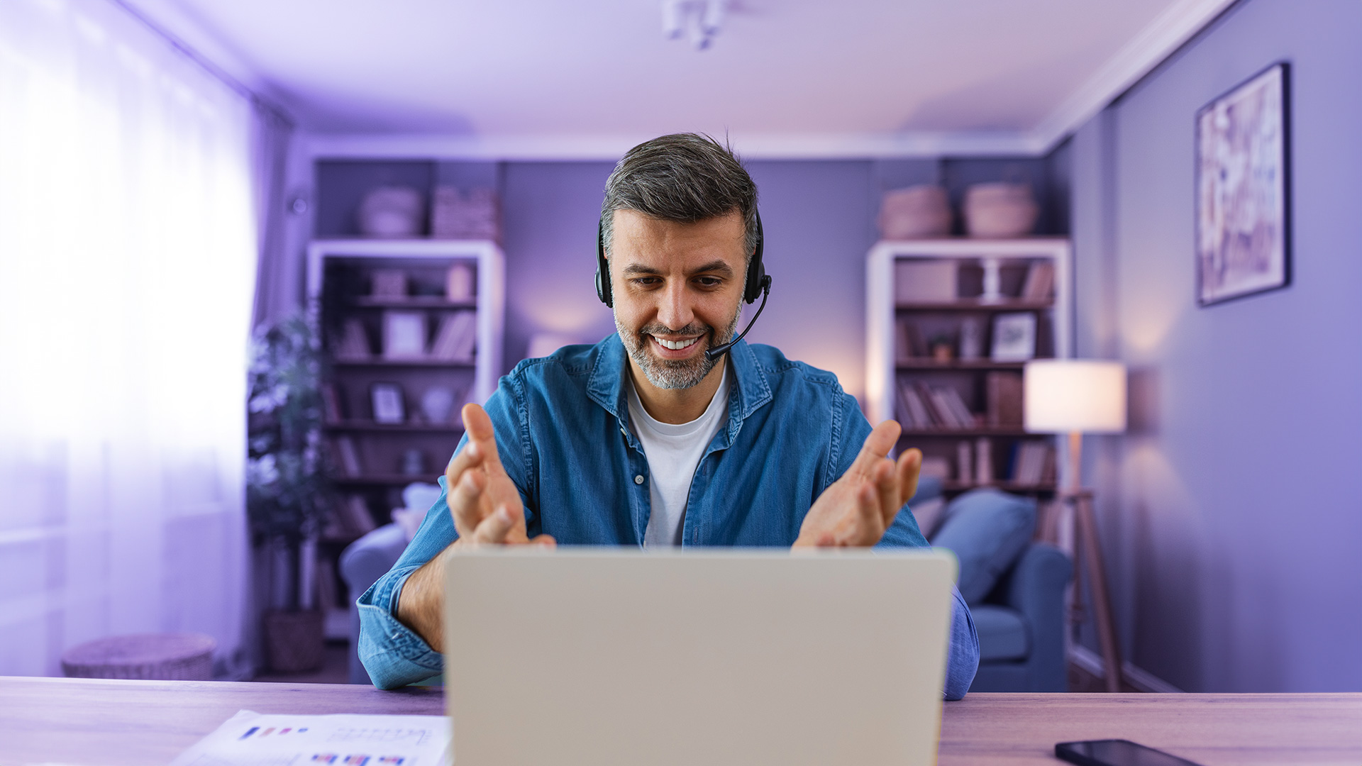 Hombre adulto sonriendo mientras hace campañas de telemarketing desde casa