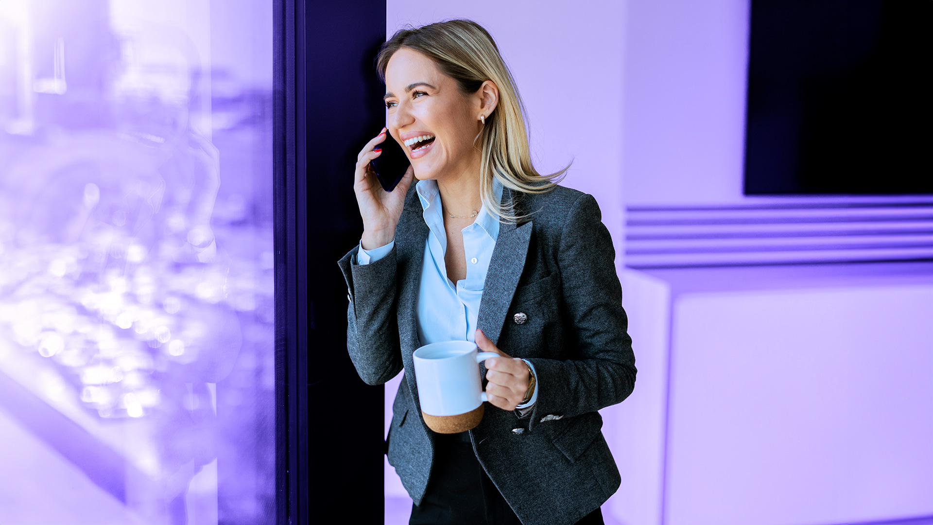 Mujer empresaria sonriendo mientras está en su despacho hablando por teléfono con un cliente