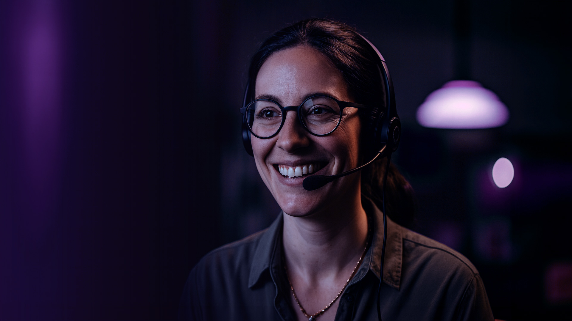 Mujer agente de telemarketing sonriente frente al ordenador