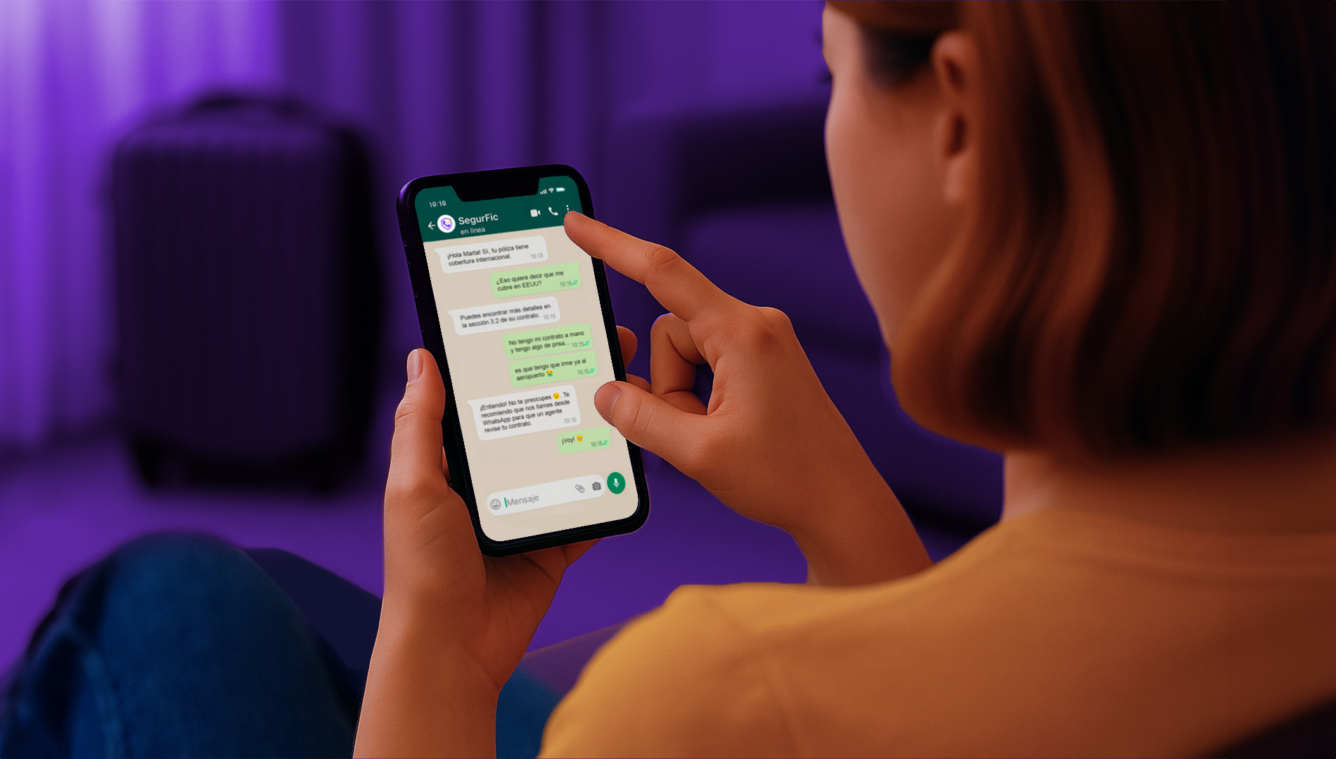 Mujer sentada en el sofá mientras chatea por WhatsApp con su aseguradora