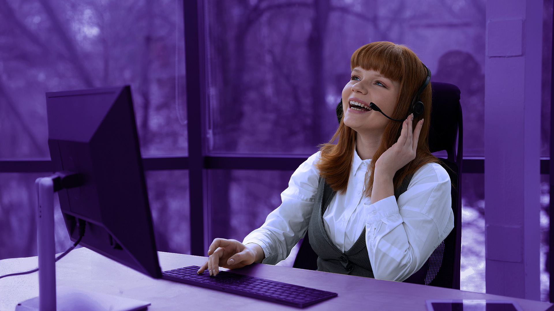 Mujer agente de contact center sonriendo mientras atiende la llamada de un cliente